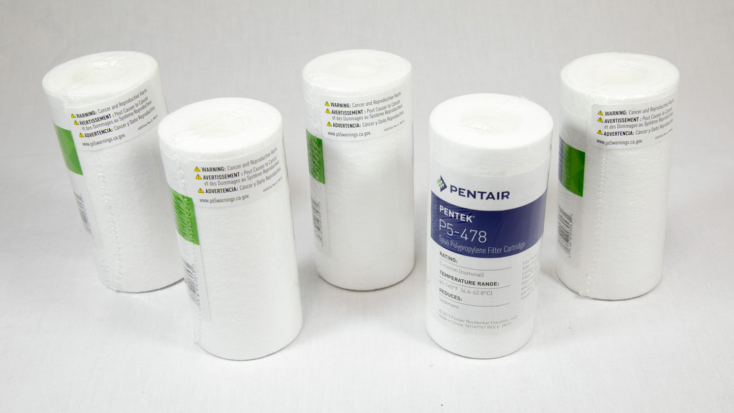 Four white filters arranged neatly on a white surface, showcasing their uniformity and design.