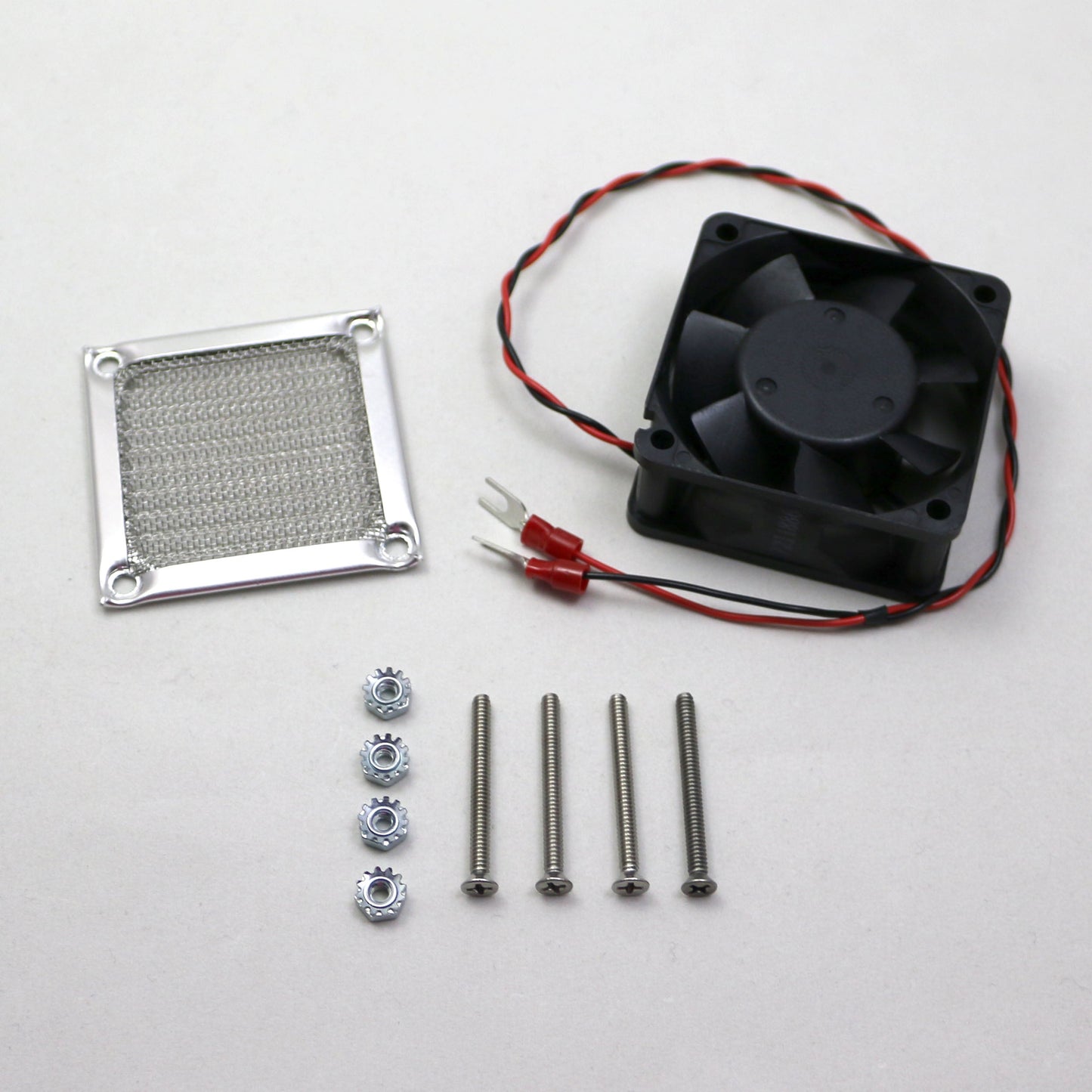 Fan assembly kit with fan, heat sink, screws, and connectors on a white background