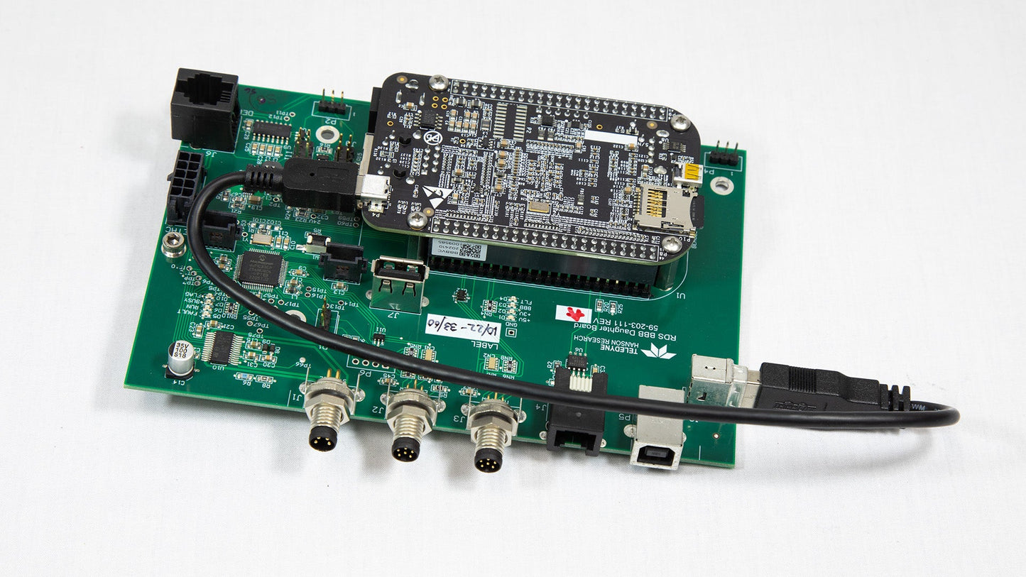 A miniature electronic board featuring an attached USB cable for power or data transfer.