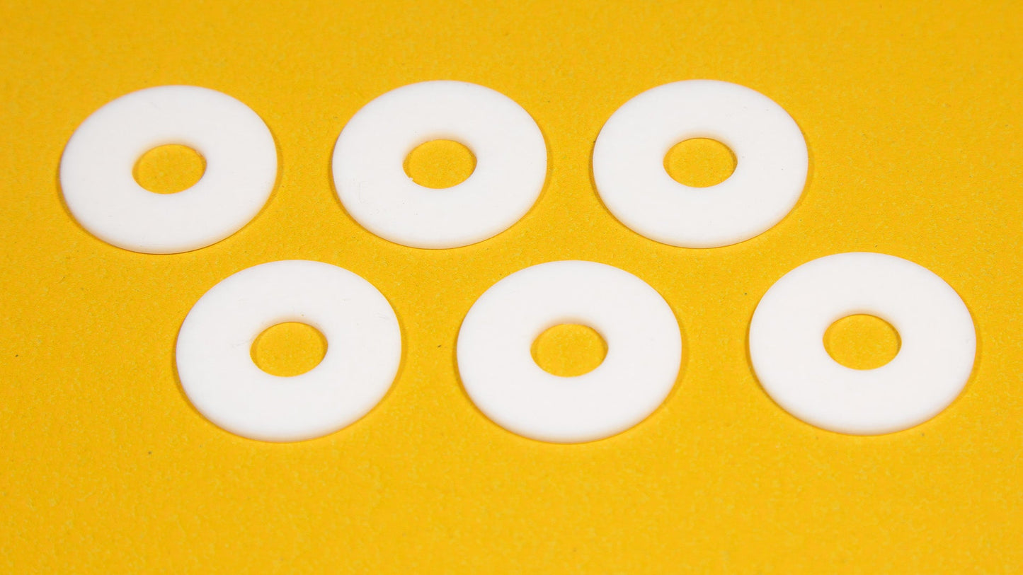 Six white round objects arranged on a bright yellow background.