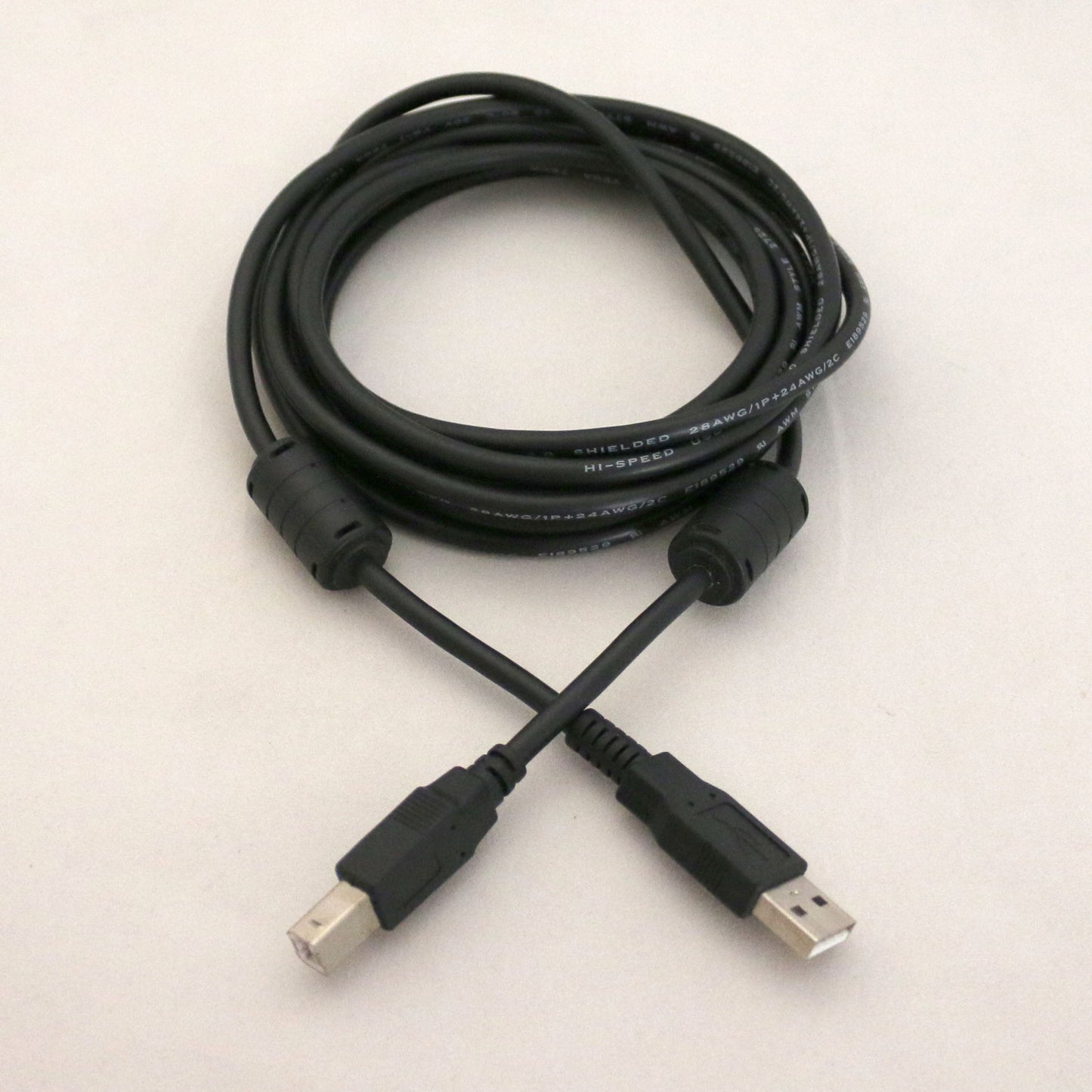 Black USB cable on a light beige background