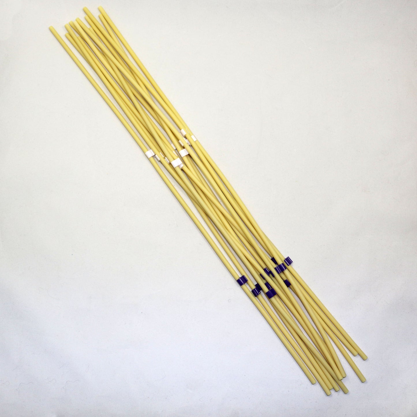Set of yellow tubing pieces with black ends on a light gray background
