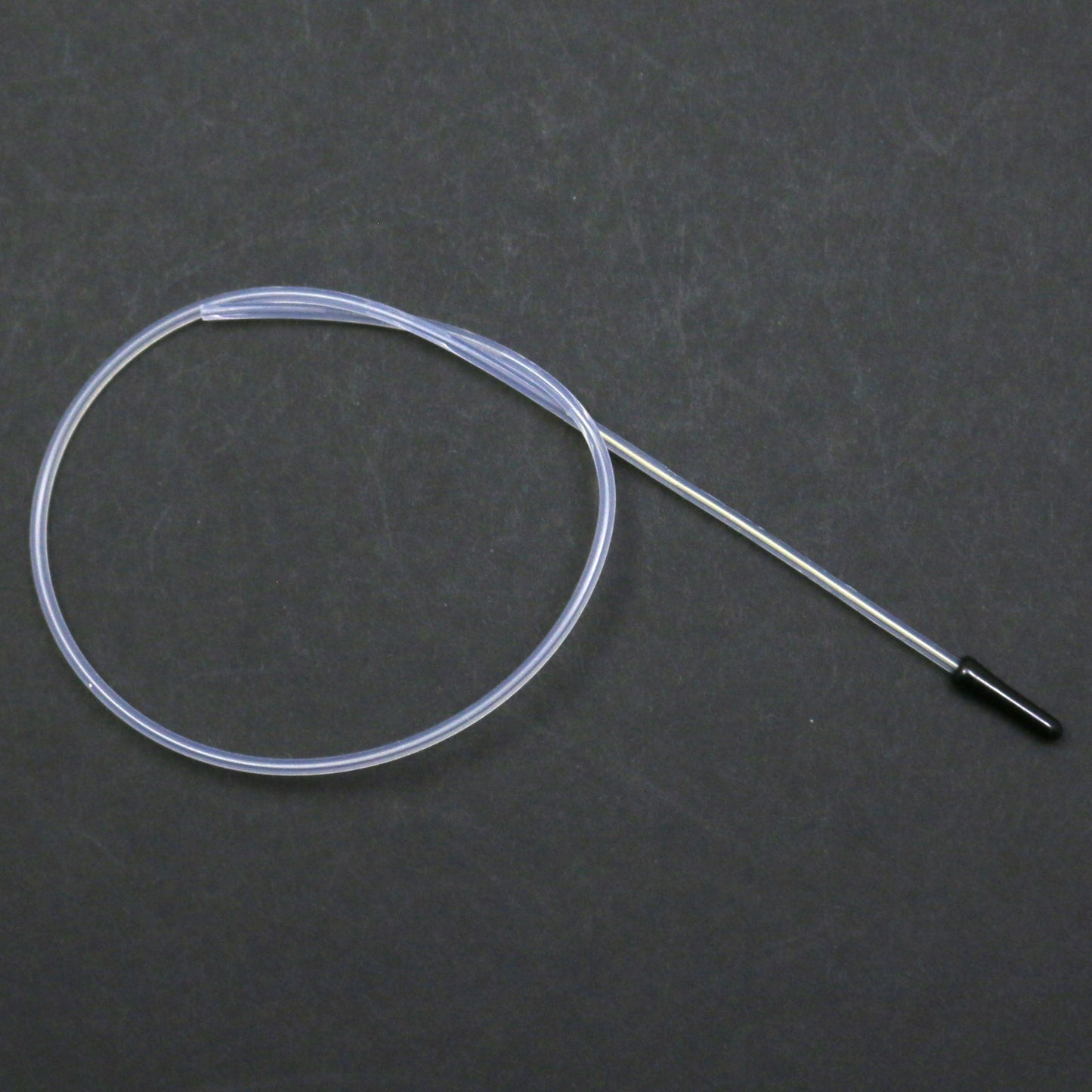 Clear tubing with a black connector on a dark gray background