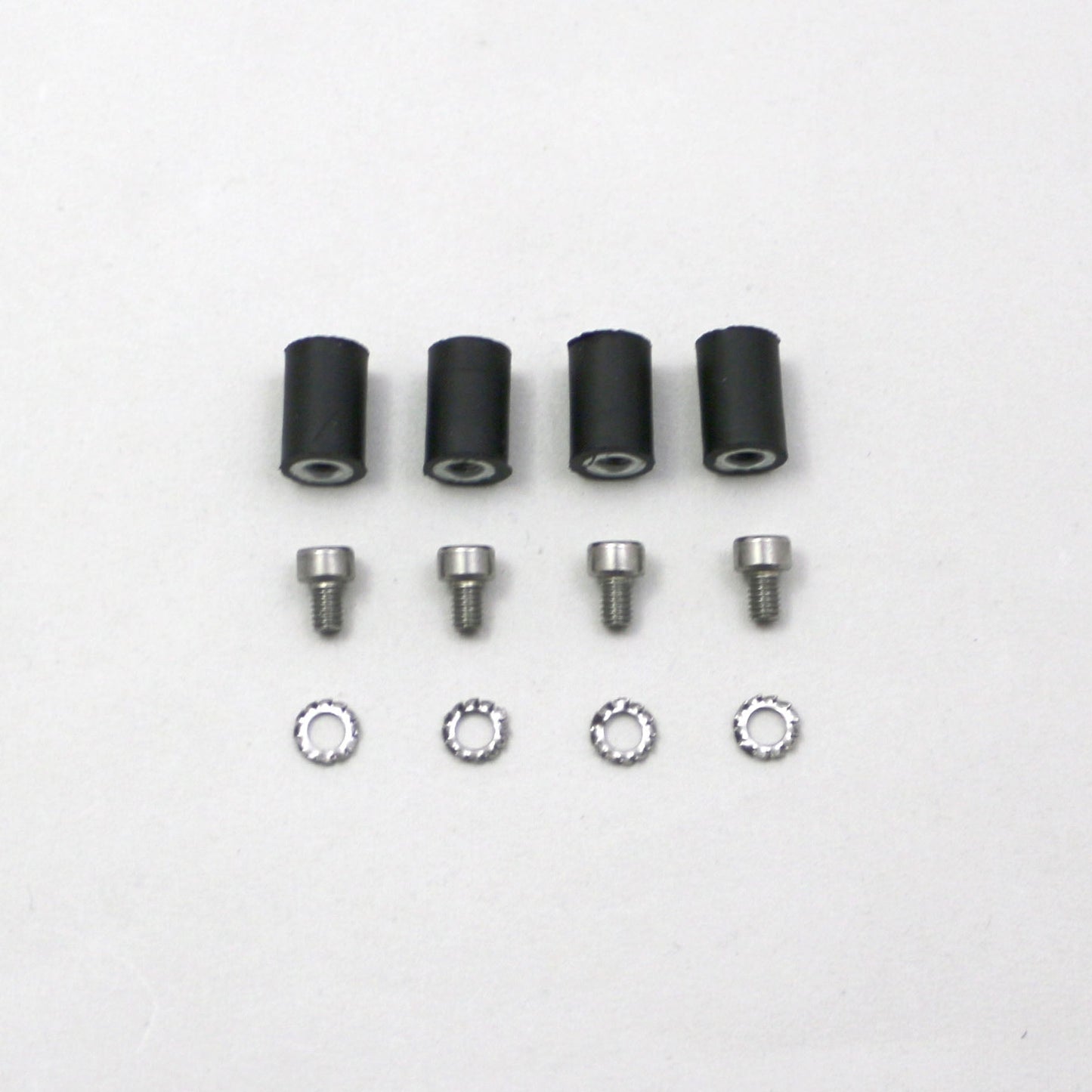 Set of black cylindrical parts and silver screws on a white background
