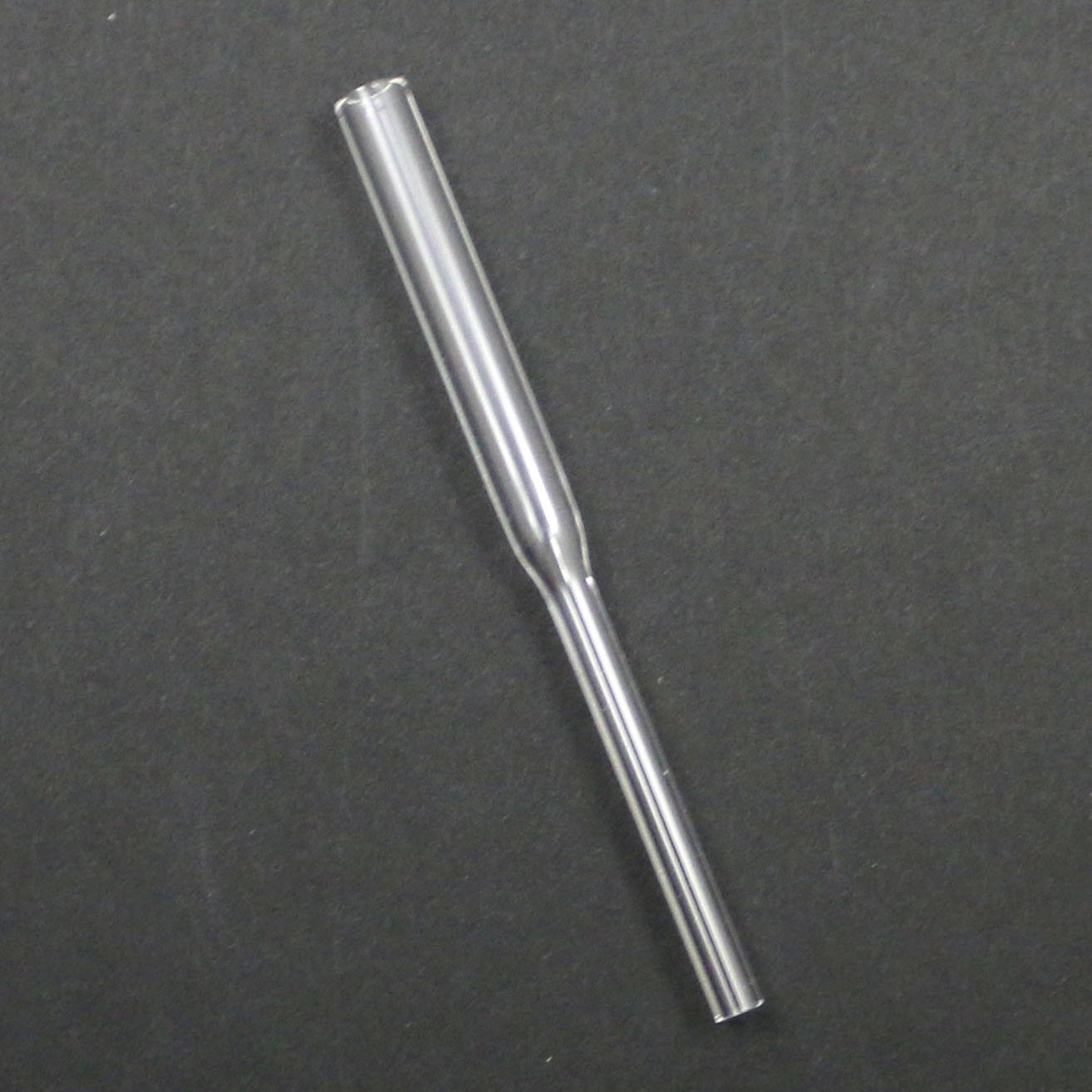 Clear glass pipe on a dark gray background