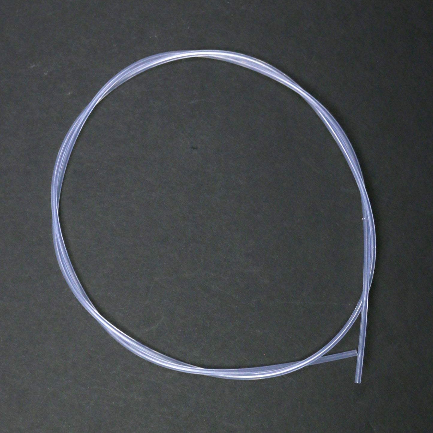 Coiled clear plastic tube on a dark gray background
