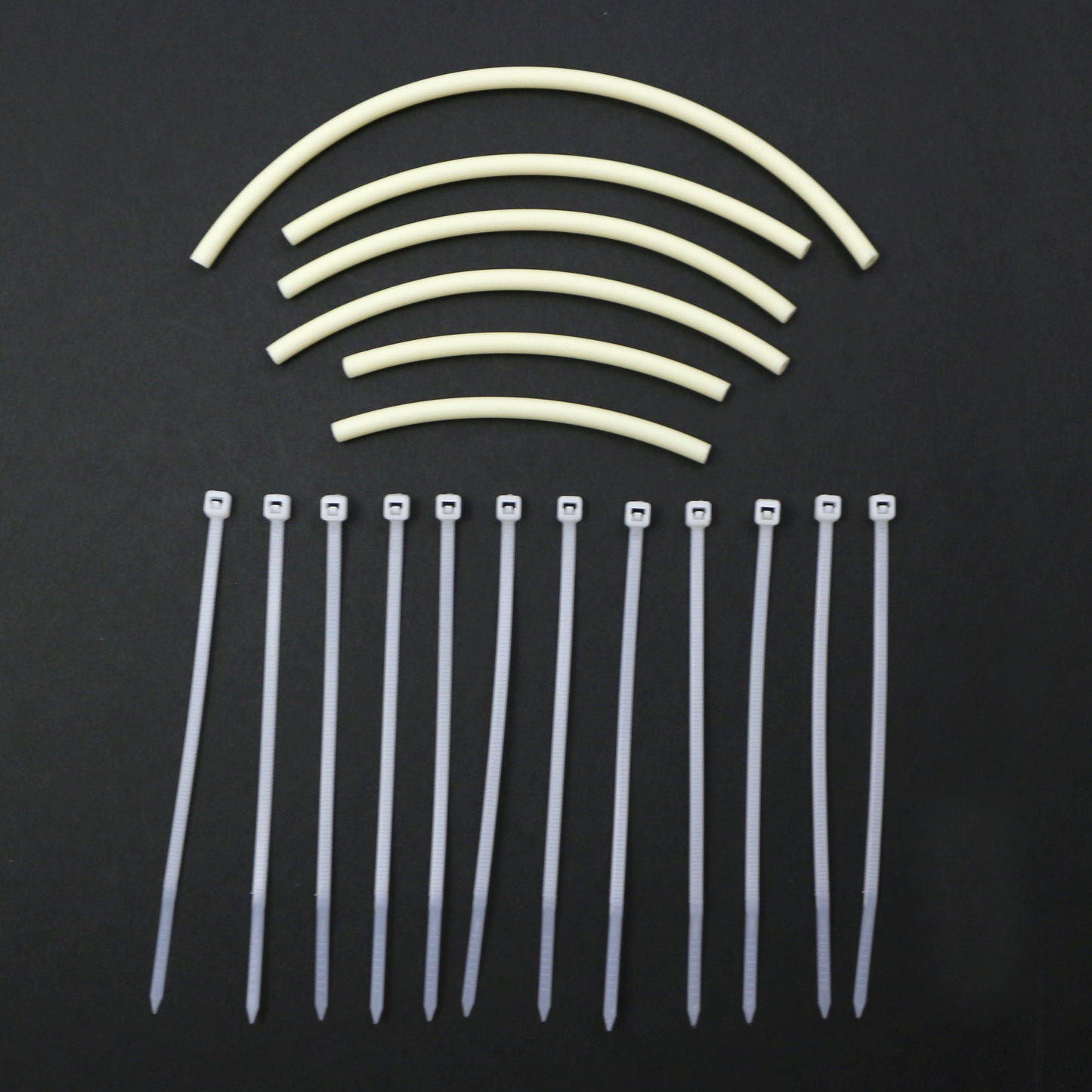 Set of cable ties and tubing pieces on a black background