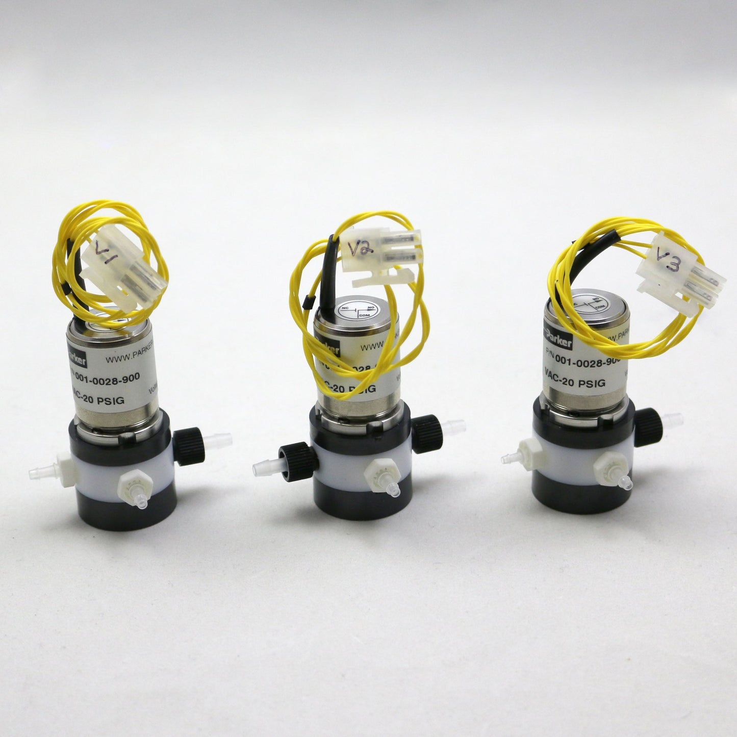 Three mechanical components with yellow wires on a white background