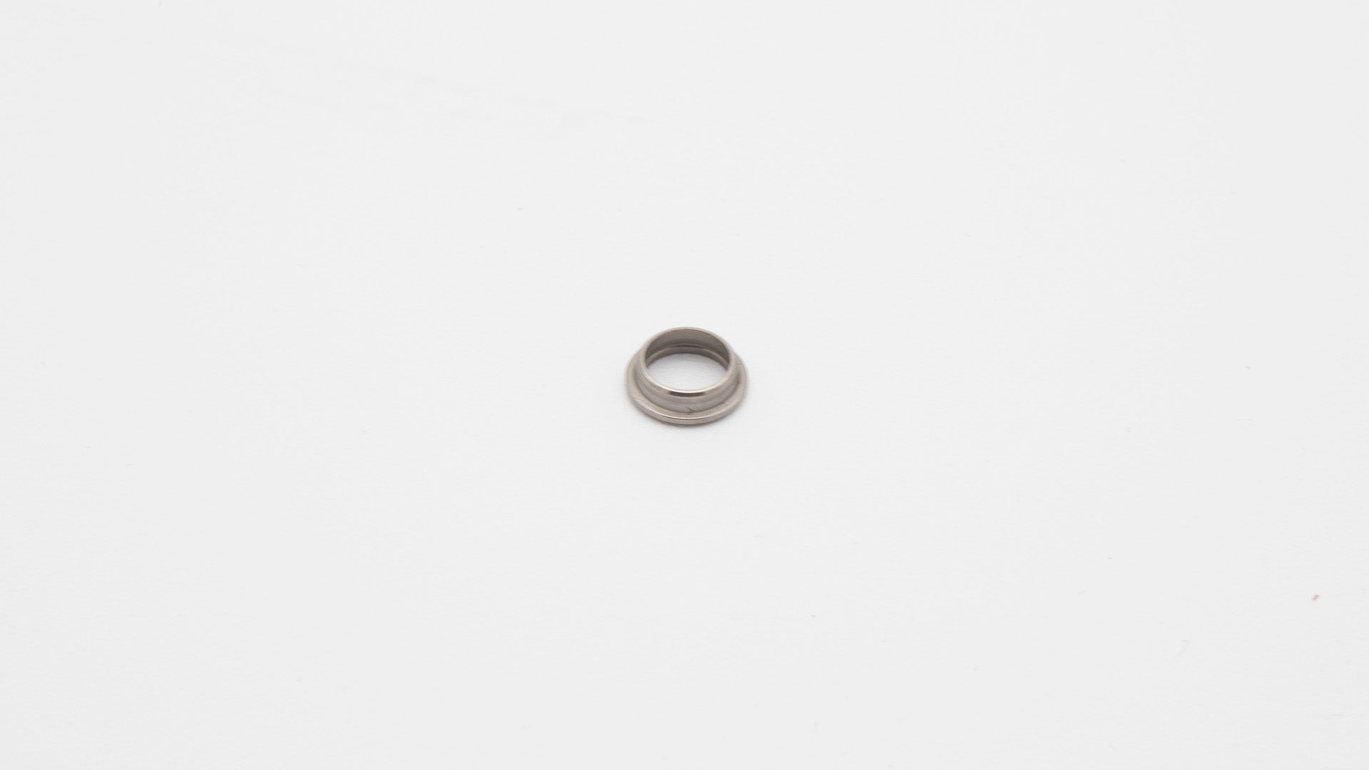 A silver round object on a white surface