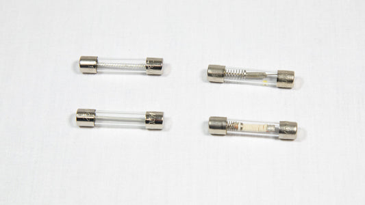 Four distinct electronic fuses arranged on a white surface.
