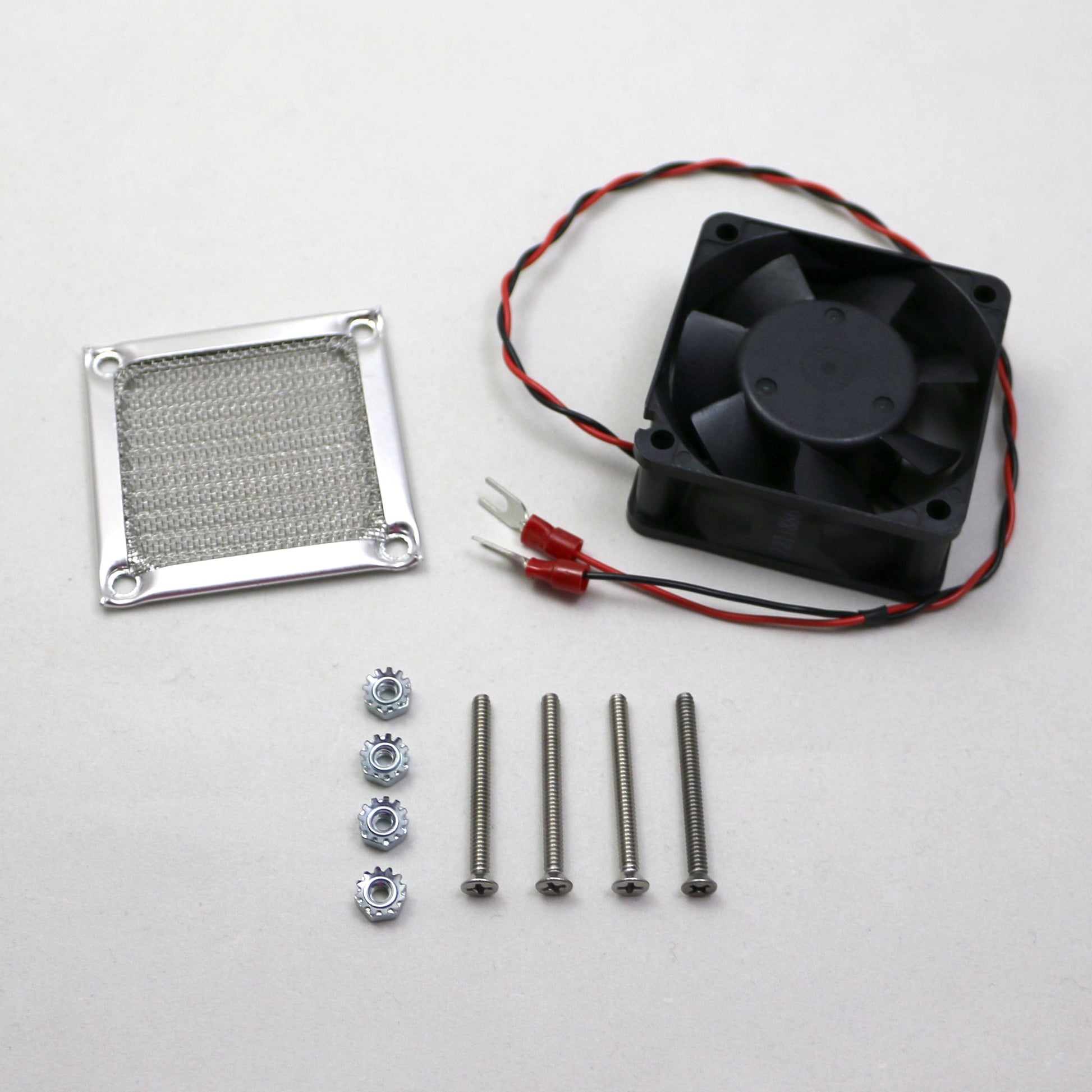 Fan assembly kit with fan, heat sink, screws, and connectors on a white background