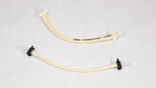 Two plastic tubes featuring connectors, positioned on a white surface.
