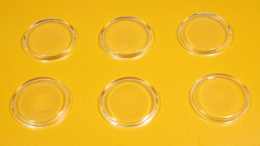 A collection of six clear oval plastic pieces displayed on a vibrant yellow background.