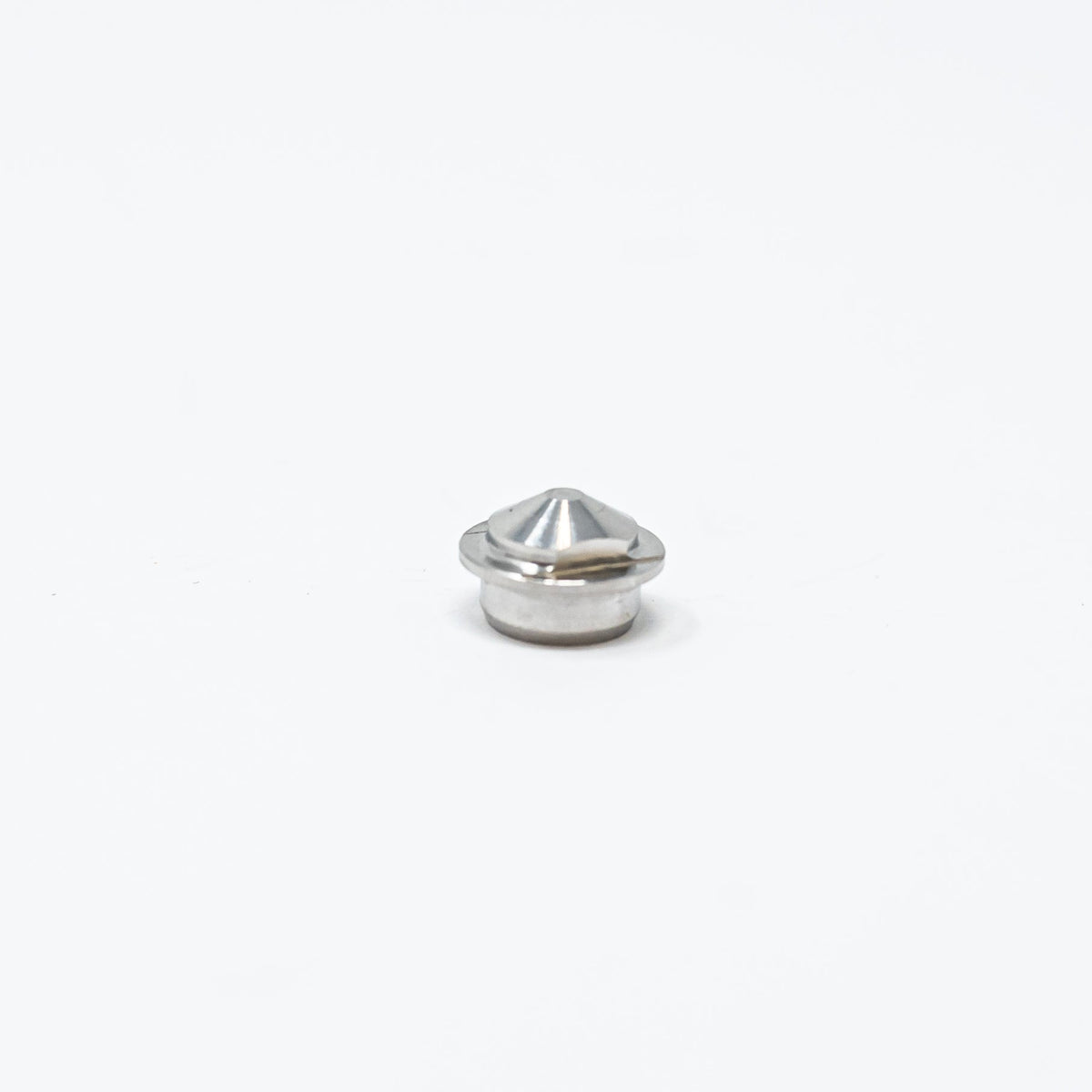 A small metal nut resting on a clean white surface, showcasing its shiny texture and circular shape.