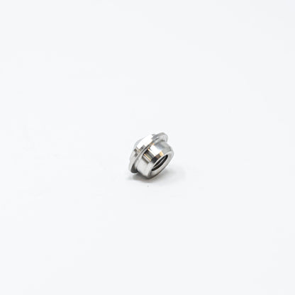 A small metal nut resting on a clean white surface, showcasing its shiny texture and circular shape.