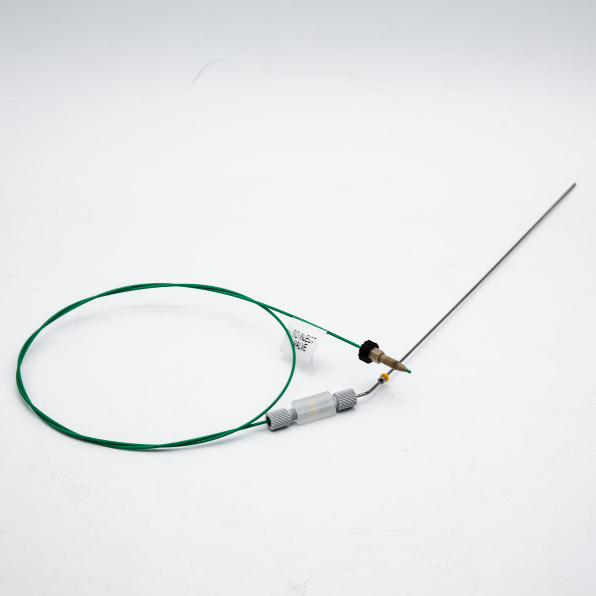 Device with green cable and needle on a white background