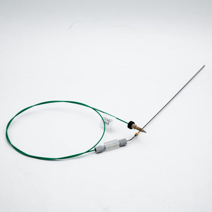 Device with green cable and needle on a white background