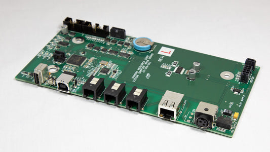A green electronic circuit board with various components displayed on top.