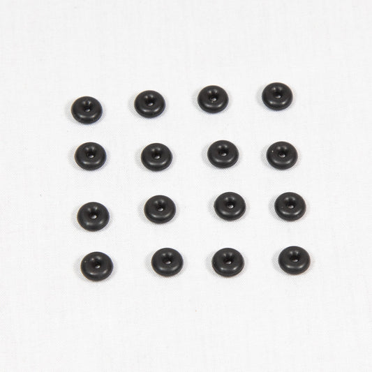 A collection of round black plastic objects arranged on a clean white surface.