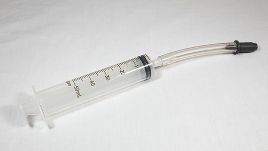 A syringe equipped with a needle and tube, commonly used in medical procedures for fluid transfer.