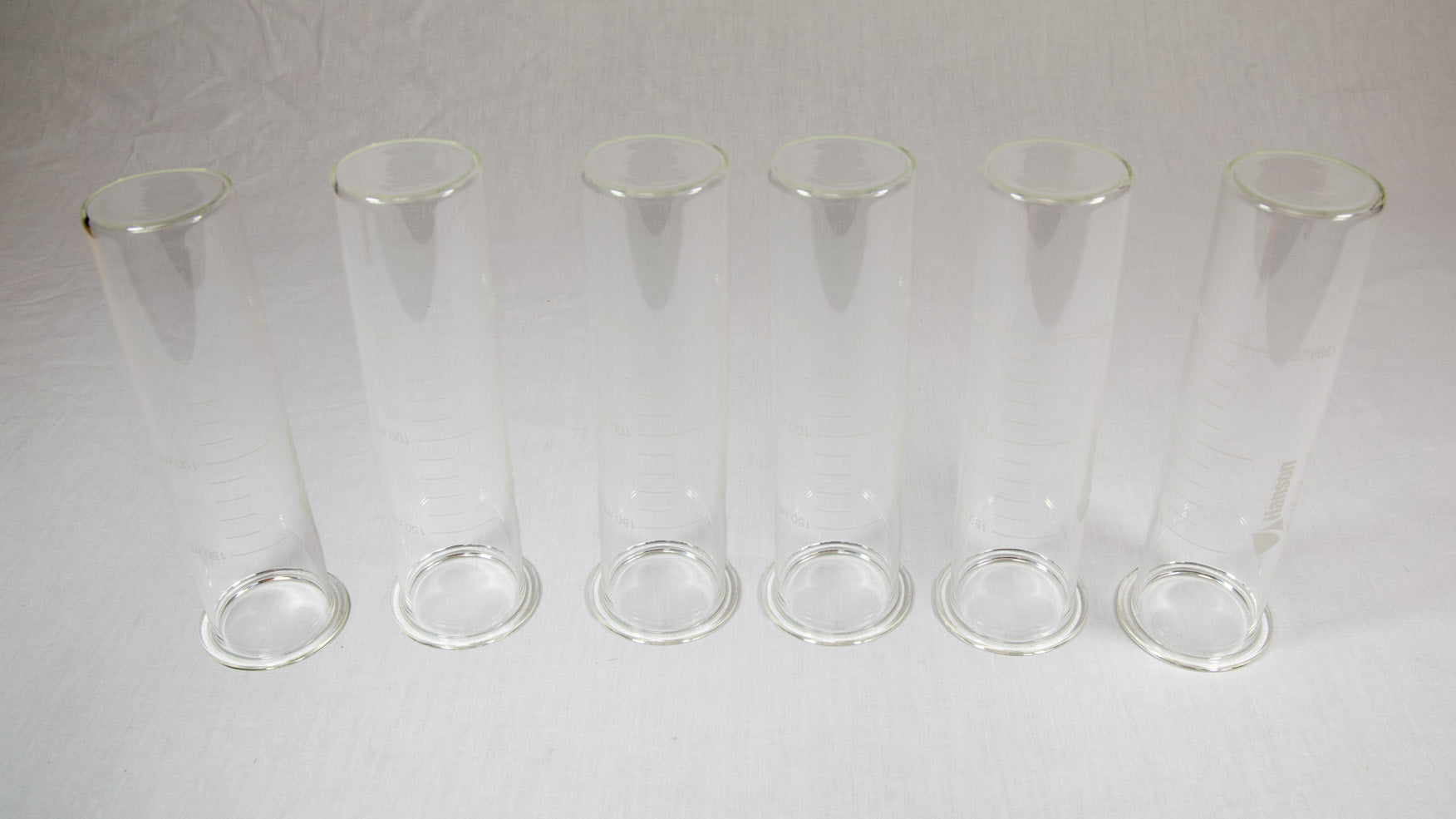 Six clear plastic containers with lids arranged neatly on a bright yellow background.