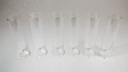 Six clear plastic containers with lids arranged neatly on a bright yellow background.