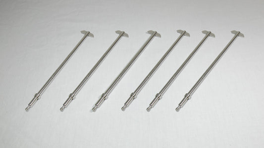Six stainless steel rods arranged neatly on a white surface, showcasing their sleek and shiny appearance.