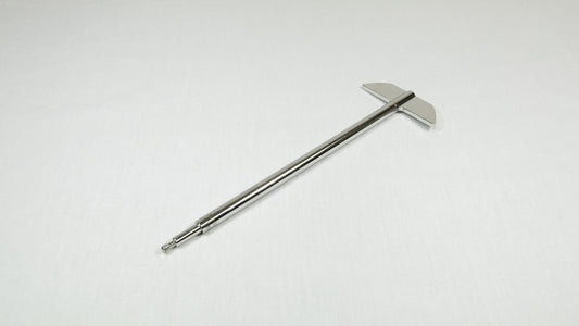 A stainless steel rod with a metal tip rests on a smooth white surface, highlighting its sleek design and minimalistic style.