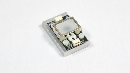 A small electronic device resting on a white surface, showcasing its compact design and modern features.