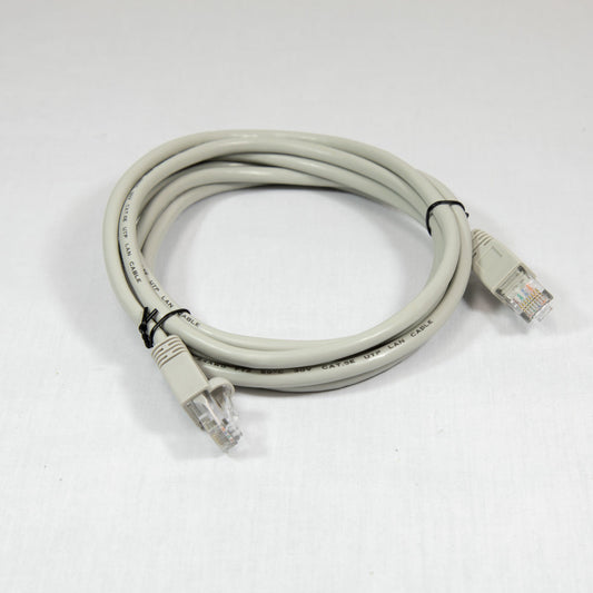 A tan Ethernet cable with connectors on both ends, coiled neatly on a surface.