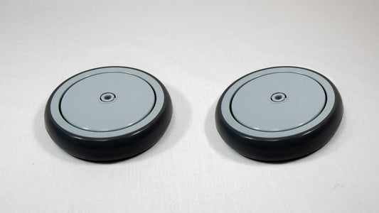 Two black and grey cylindrical objects placed on a white surface, showcasing a simple and minimalist design.