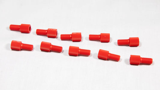 A collection of red plastic threaded fittings arranged on a clean white surface.