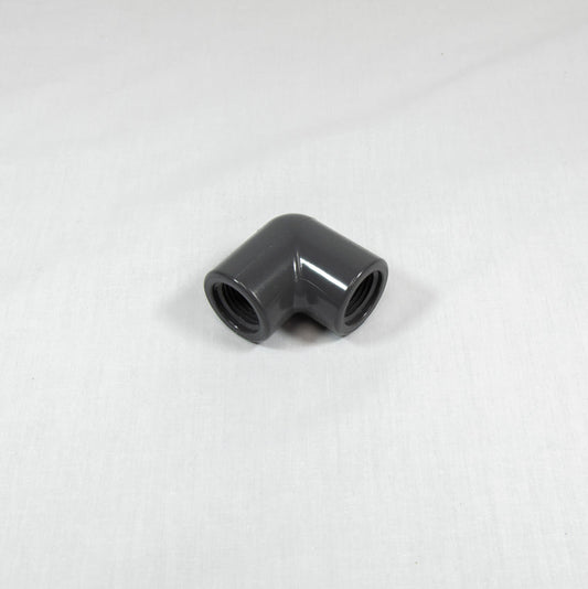 A grey plastic pipe fitting displayed against a white background, highlighting its shape and texture.