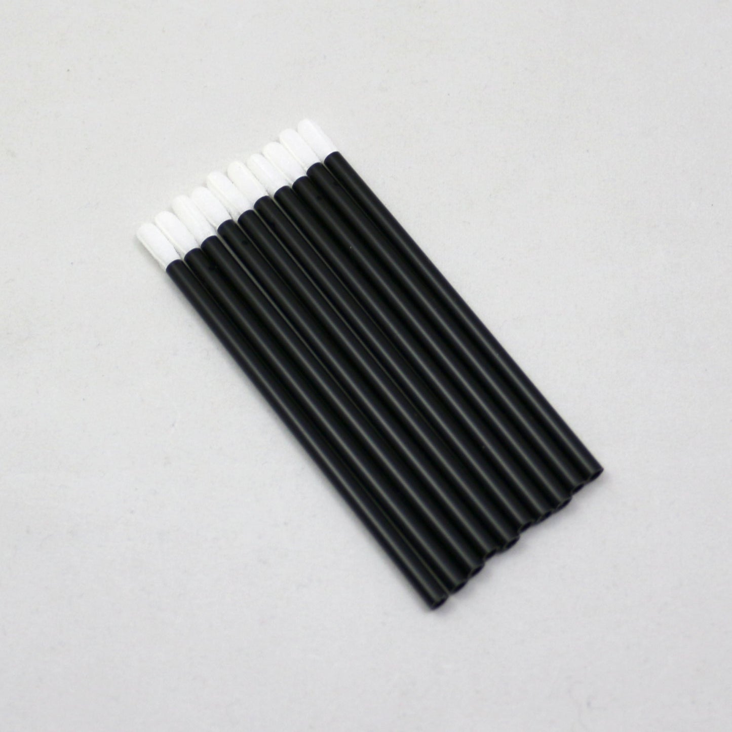 Black markers with white caps on a gray background