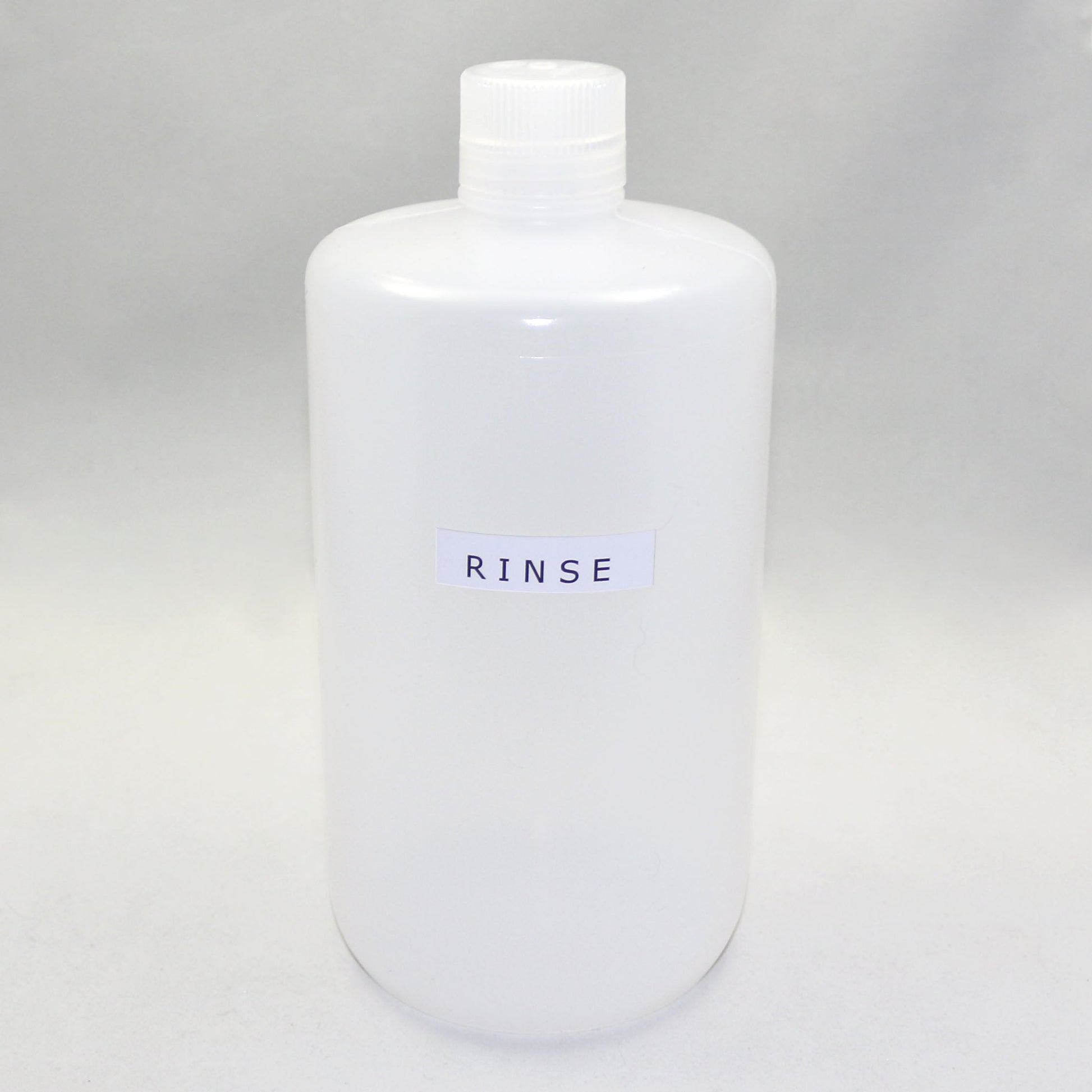 White bottle labeled 'RINSE' on a gray background