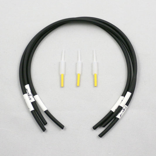 Black tubing pieces with plastic connectors on a gray background