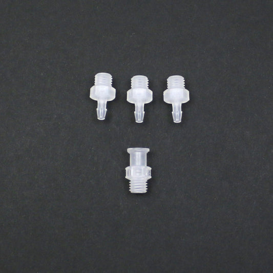 Four clear plastic nozzles on a dark gray background