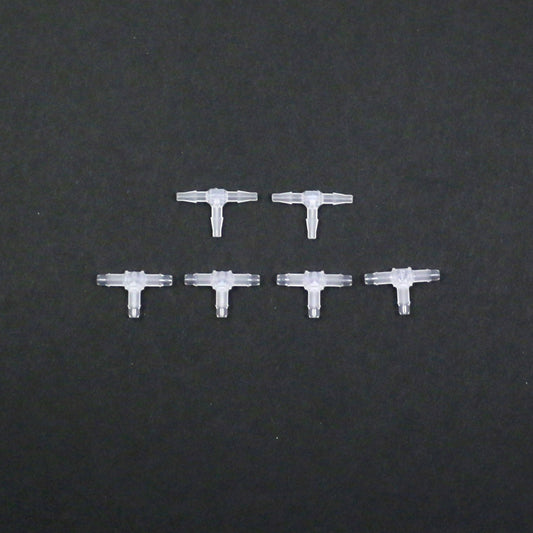 Set of six clear plastic connectors on a black background