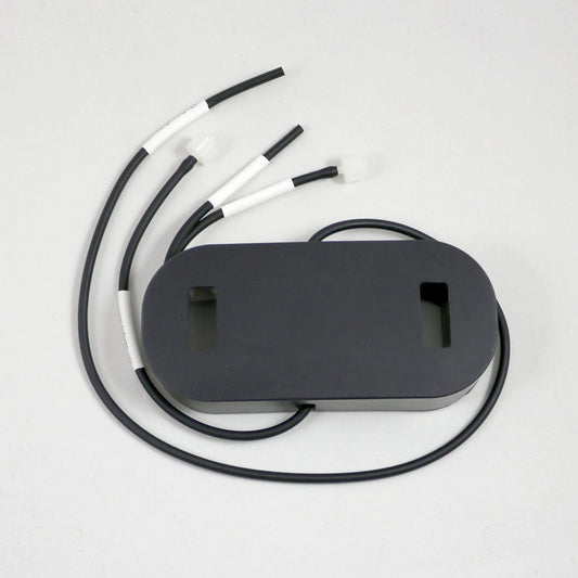 Black oval device with multiple cables on a light gray background
