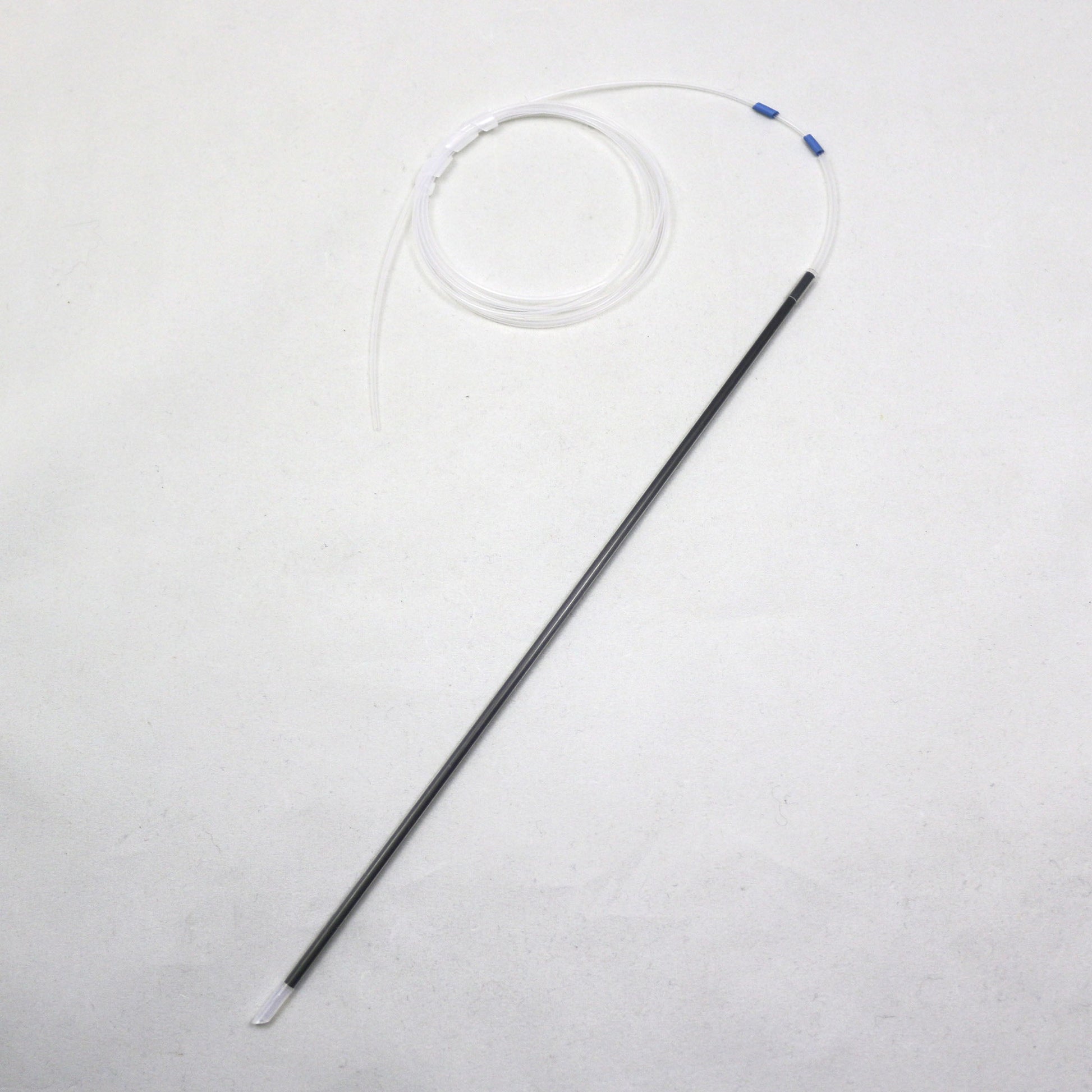 Long thin black object with a white circular component on a light gray background