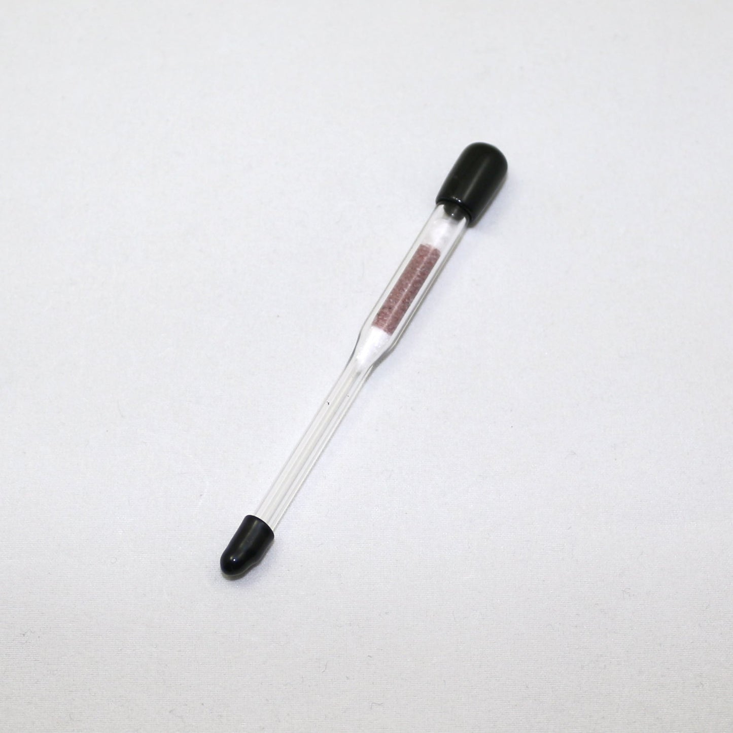 Glass hydrometer with black ends on a white background