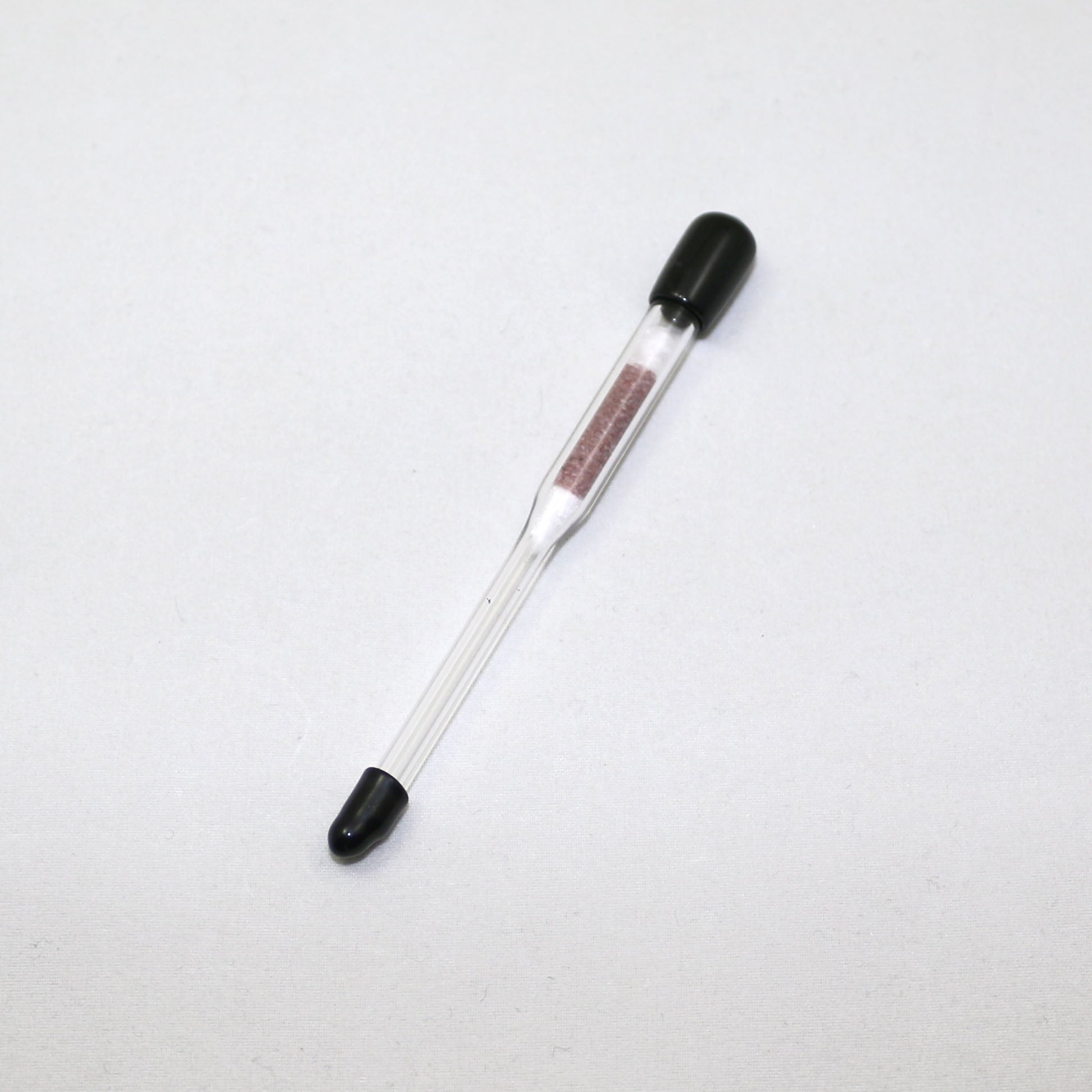 Glass hydrometer with black ends on a white background