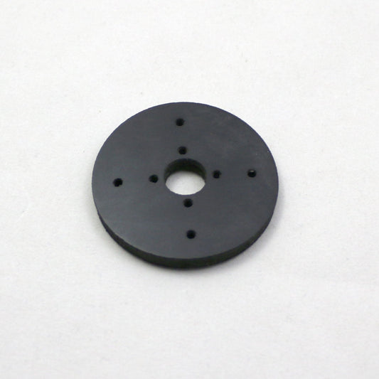 Black circular object with multiple holes on a white background