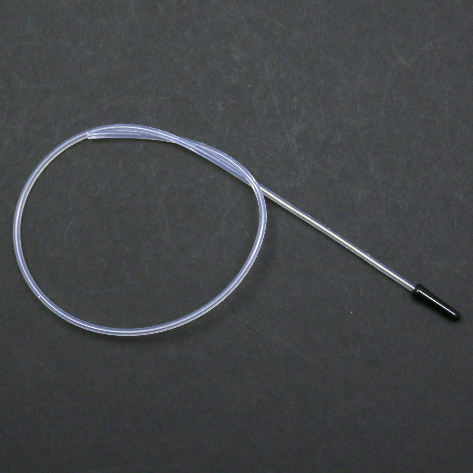 Clear tubing with a black connector on a dark gray background