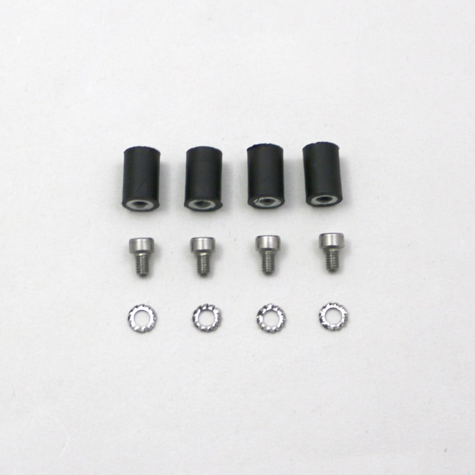 Set of black cylindrical parts and silver screws on a white background