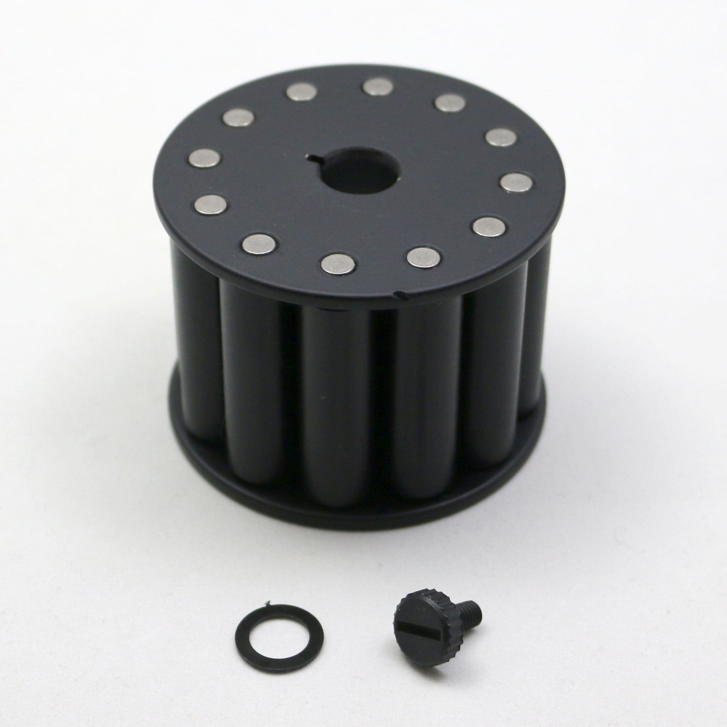 Black cylindrical component with metallic bolts on a white background