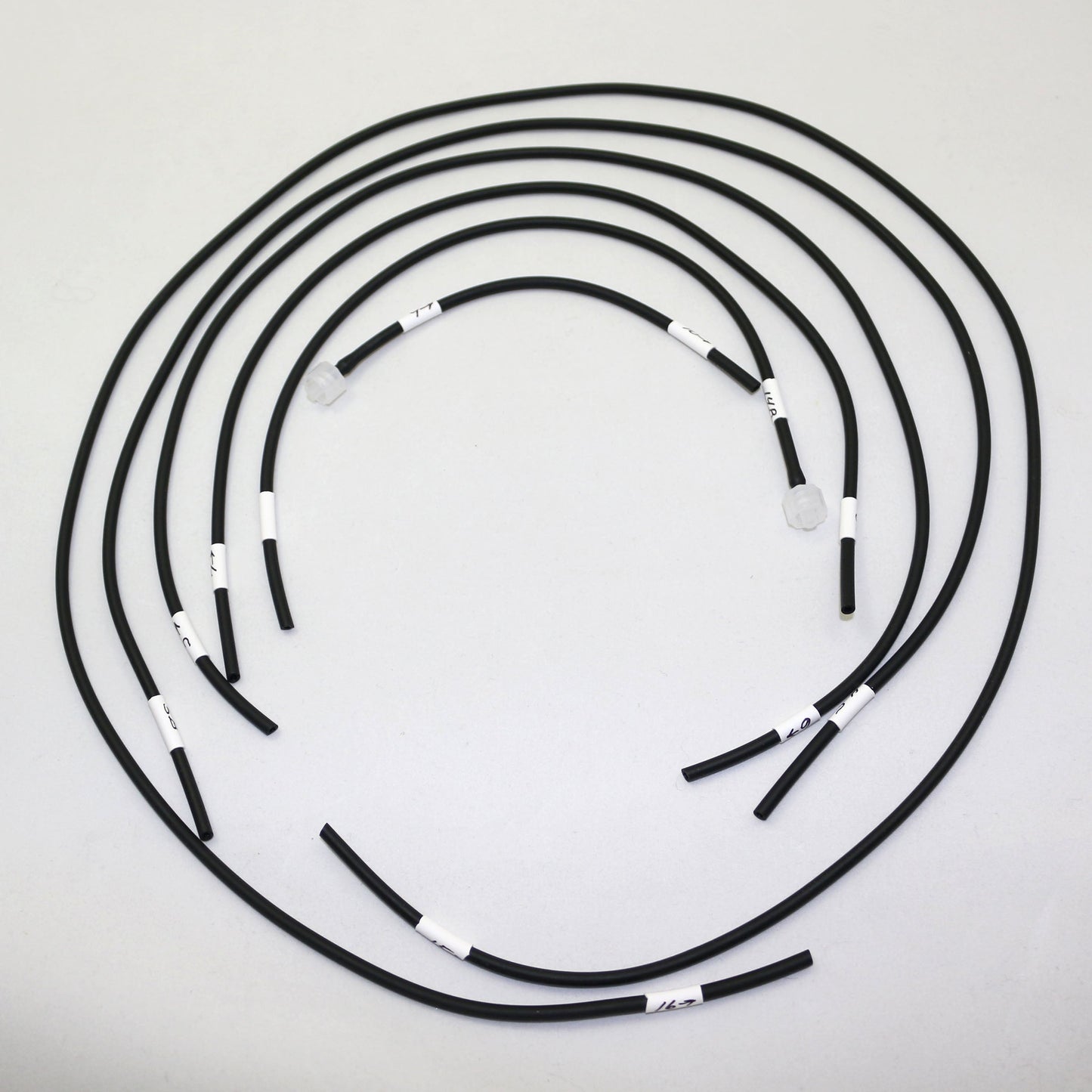 Set of black hoses with white labels arranged in a circular pattern on a light gray background