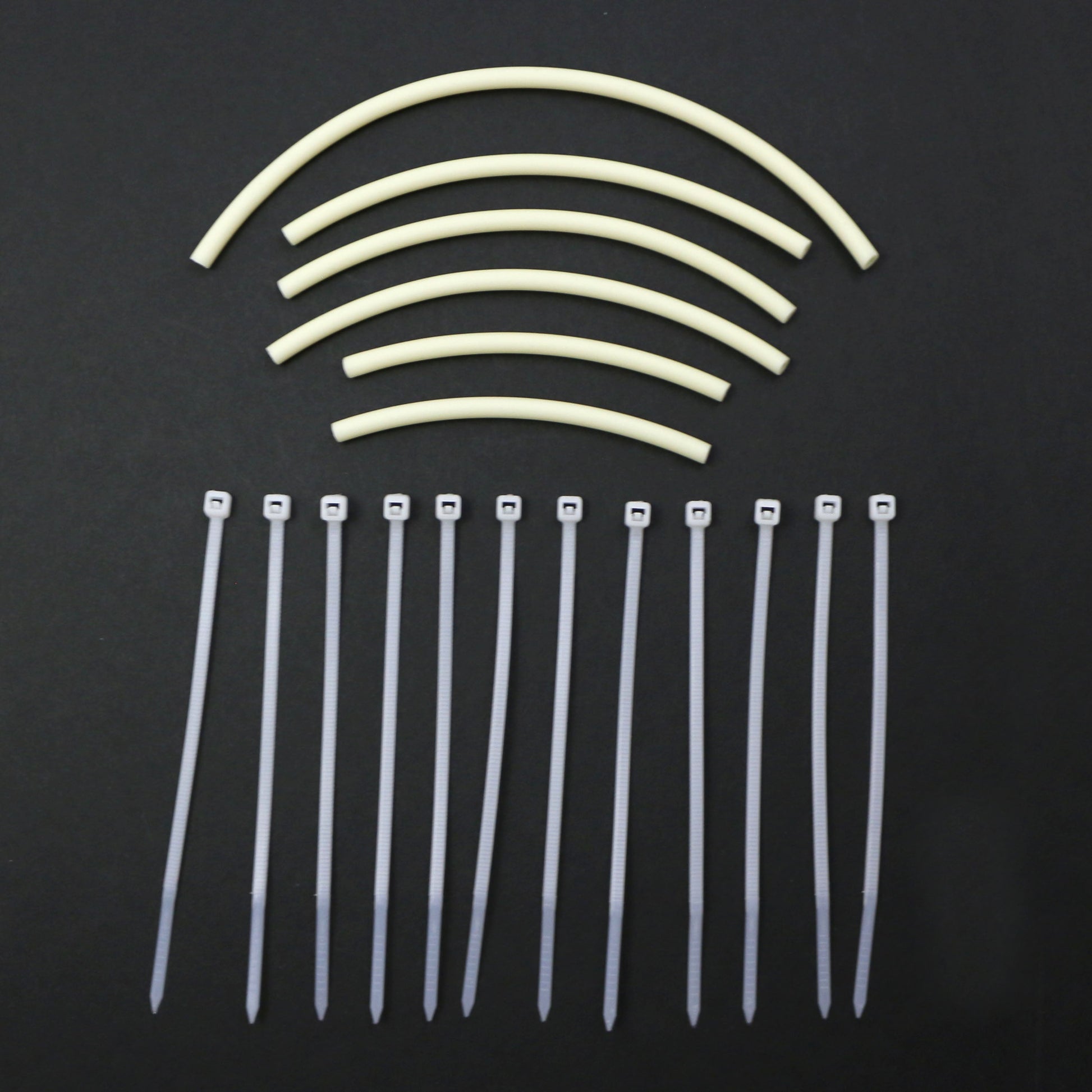 Set of cable ties and tubing pieces on a black background