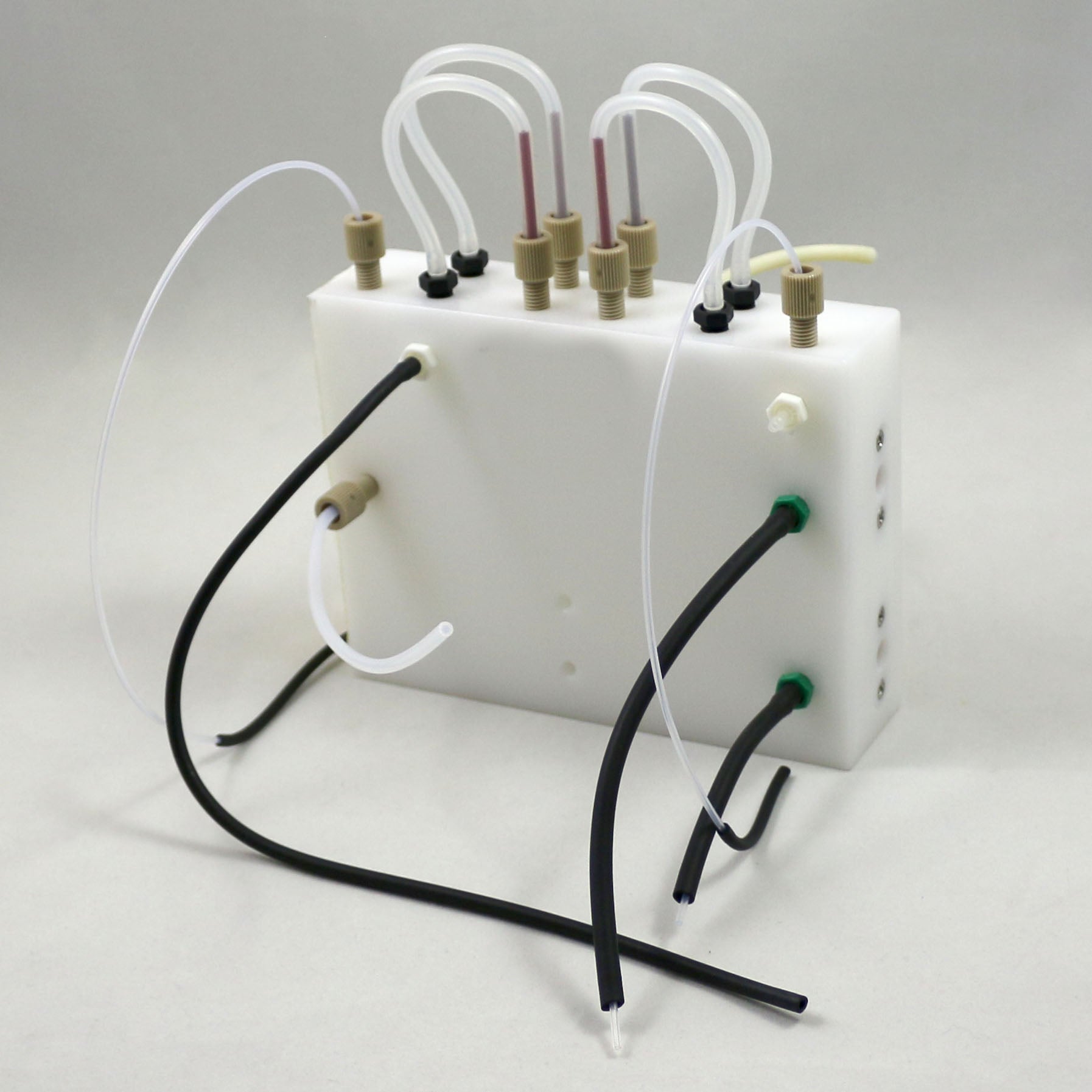 White plastic container with tubes and connectors on a gray background