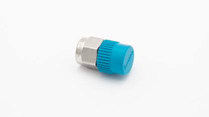 A blue plastic threaded fitting placed on a clean white surface, showcasing its design and color contrast.